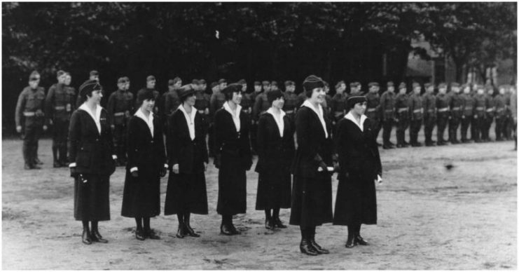 Signal Corps Telephone Girls receive decorations. 322nd Field Signal Bn. in the background. From left to right: front row, Suzanne Prevot and Marie A. LeBlanc, who were decorated. Back row, Grace D. Banker, Cordelia Dupuis, Janet R. Jones, Helen Orb, and Eileen Munro. Coblenz, Rhenish Prussia, Germany.8 July 1919