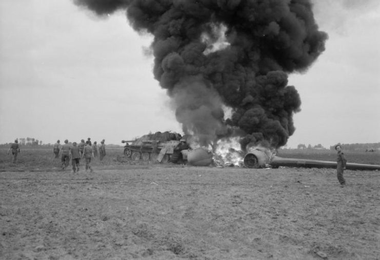 An American C-47 aircraft, hit by flak returning from the Market-Garden drop, burns after crash-landing into a knocked-out German Jagdpanther in a field near Gheel in Belgium, 17 September 1944.