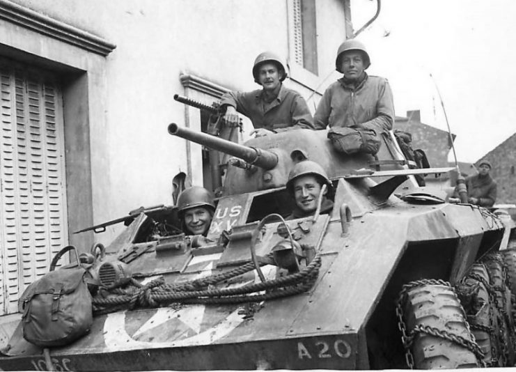 US soldiers in M8 of the 106th Cavalry Regiment in small French village.