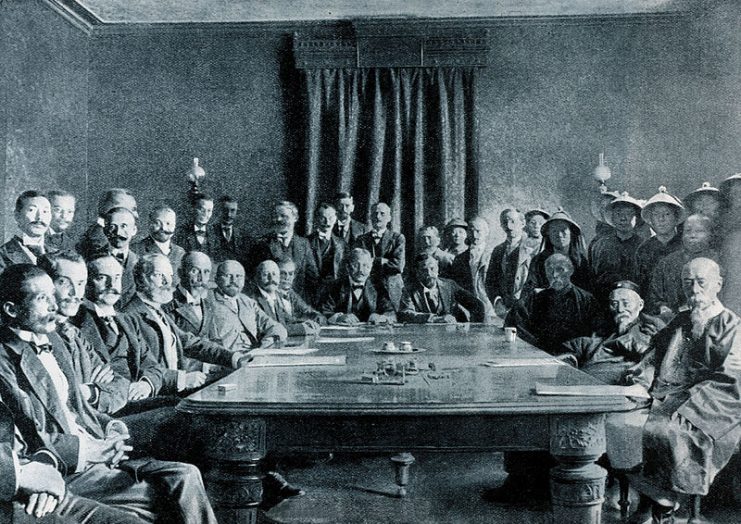 Signing of the Boxer Protocol. Left, from left to right: F.M Knobel from Netherland (only see his hands); K. Jutaro from Japan; G. S. Raggi from Italy; Joostens from Belgium; C. von Walhborn from Austria-Hungary; B. J. Cologán from Spain; M. von Giers from Russia; A. Mumm for German Empire; E. M. Satow from United Kingdom; W. W. Rockhill from US; P. Beau from France; I-Kuang; Li Hongzhang; Prince Qing