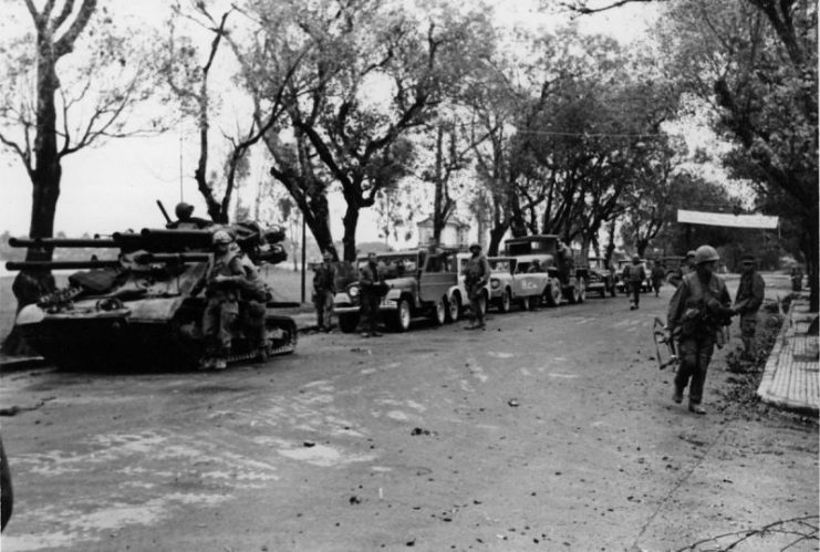 An M50 Ontos leads evacuation convoy of commandeered vehicles, Hue, Vietnam.