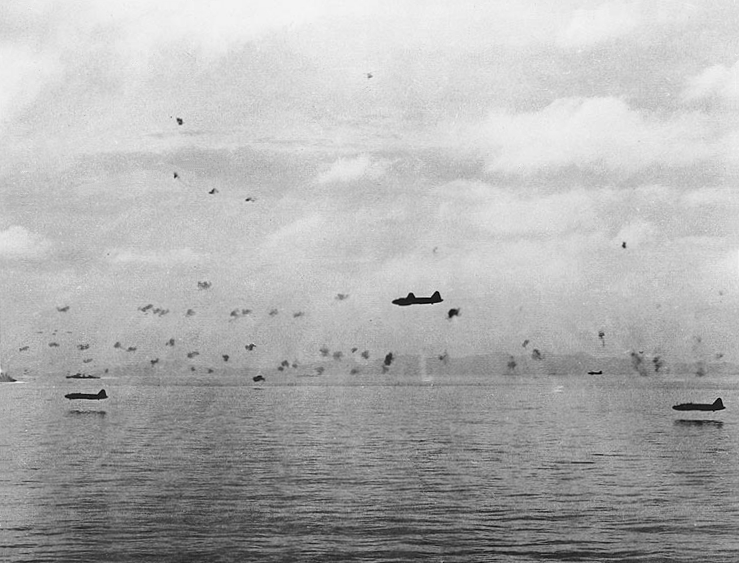 Japanese Navy Type 1 land attack planes (Mitsubishi G4M1 “Betty”) fly low through anti-aircraft gunfire during a torpedo attack on U.S. Navy ships maneuvering between Guadalcanal and Tulagi in the morning of 8 August 1942. Note that these planes are being flown without bomb-bay doors.