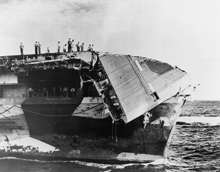 The bow of the U.S. Navy aircraft carrier USS Hornet (CV-12) showing damage received in a typhoon on 5 June 1945. The flight deck has been bent downwards over the bow and the plating torn away revealing the control position for the starboard catapult.