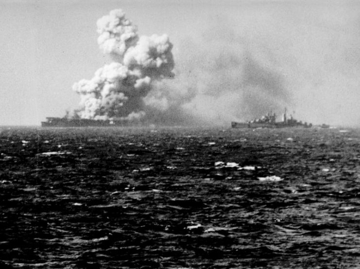 Torpedoes aboard the U.S. Navy light aircraft carrier USS Princeton (CVL-23) explode on 24 October 1944, after she was bombed by a Japanese aircraft during the Battle for Leyte Gulf. The light cruiser USS Reno (CL-96) is visible on this side of the Princeton.