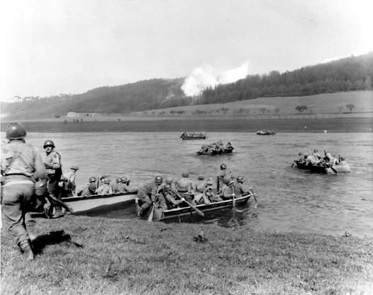 From newly captured town, members of the 16th Infantry Regiment, 1st Infantry Division, cross the Weser River in assault boats to take Furstenberg. 8 April 1945.
