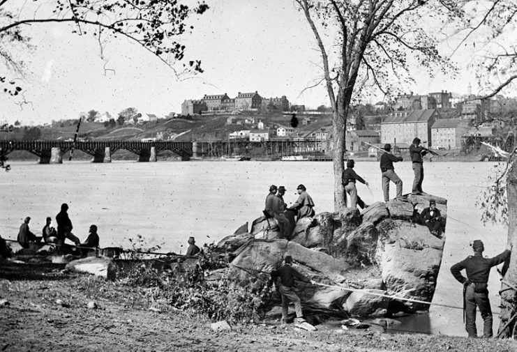 Union soldiers on the Mason’s Island (Theodore Roosevelt Island) in 1861. Behind them is the Potomac Aqueduct Bridge and Georgetown University on top of the hill. During the Civil War (1861-1865), the island served as a storage and distribution site, and also as a training camp for Union troops.
