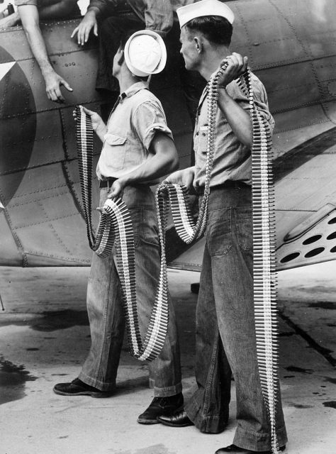 U.S. Navy ordnancemen loading belted cartridges into a Douglas SBD-3 Dauntless at Naval Air Station in Norfolk, Virginia (USA), in 1942.