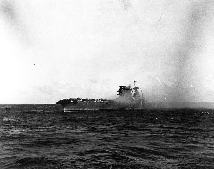 A destroyer is alongside of the U.S. Navy aircraft carrier USS Lexington (CV-2) as she is abandoned during the afternoon of 8 May 1942.