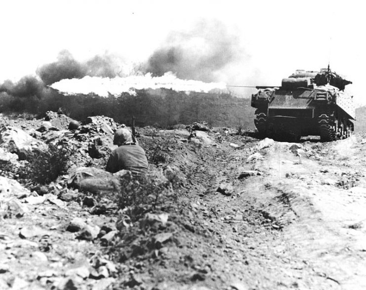 An M4 Sherman tank equipped with a flamethrower clearing a Japanese bunker on Iwo Jima, March 1945.
