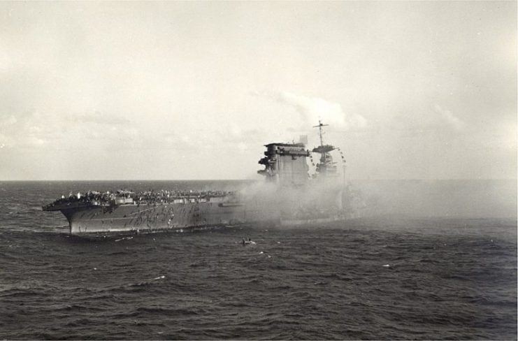 Crewmen abandon ship on board the U.S. aircraft carrier USS Lexington (CV-2) after the carrier was hit by Japanese torpedoes and bombs during the Battle of the Coral Sea, on 8 May 1942.