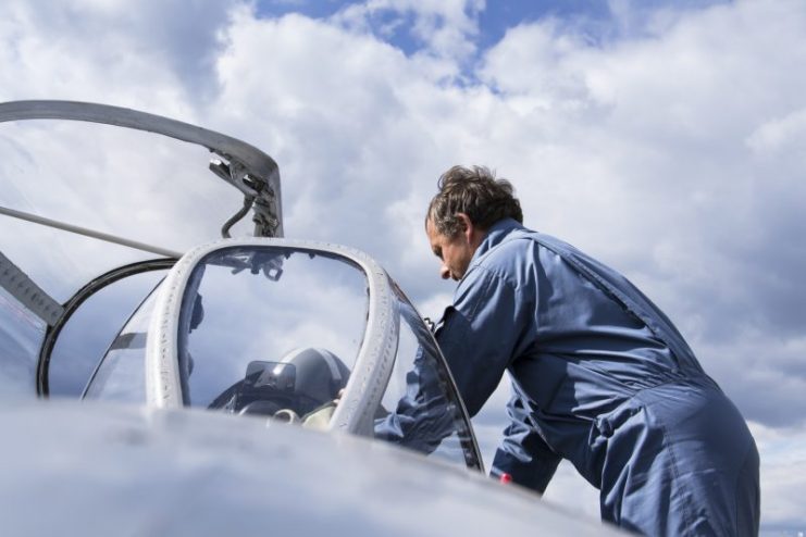 The pilot of jet fighter aircraft Mikoyan-Gurevich MiG-15 standing on a runway