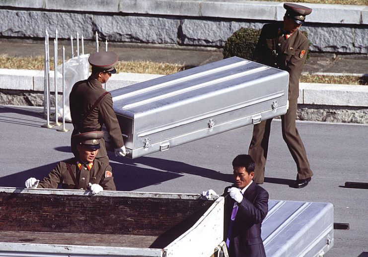 Korean People’s Army Soldiers unload nine caskets of remains which they will repatriate during a repatriation ceremony.