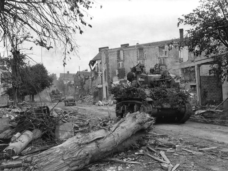 Light Tank M5 (Stuart) passes through the wrecked streets of Coutances in Normandy