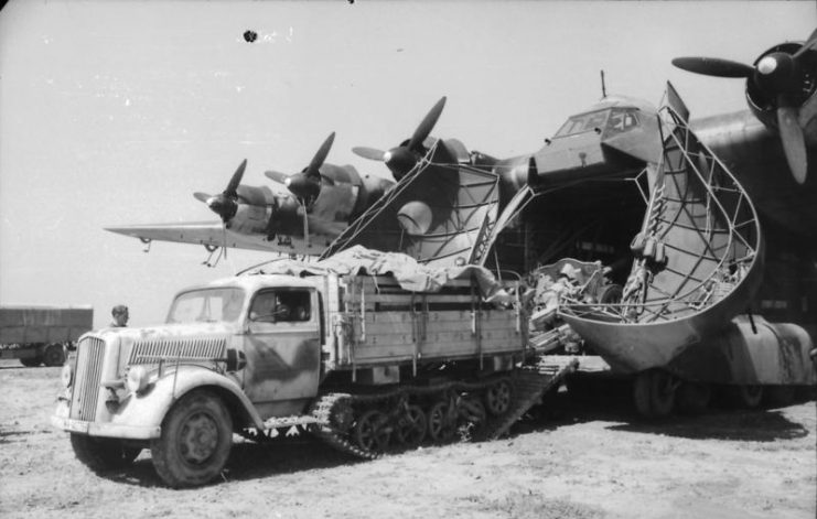 Opel Maultier towing an artillery piece off a Me-323. By Bundesarchiv-CC-BY-SA 3.0 de