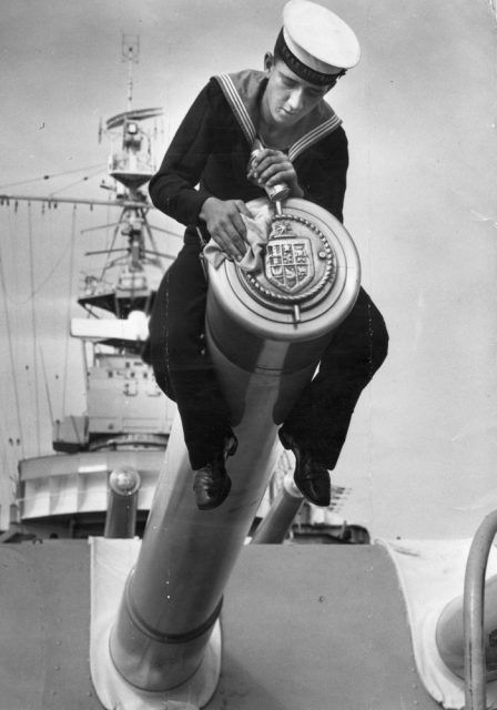 Sailor polishing the tampion of an 8-inch gun on HMAS Australia.