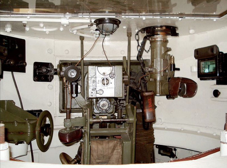 Interior of T-26 mod. 1933 turret, looking forward at the 45 mm 20K tank gun breech. The TOP-1 telescopic sight is to the left, and the coaxial DT tank machine gun and PT-K commander panoramic sight is to the right.Photo Balcer CC BY 2.5