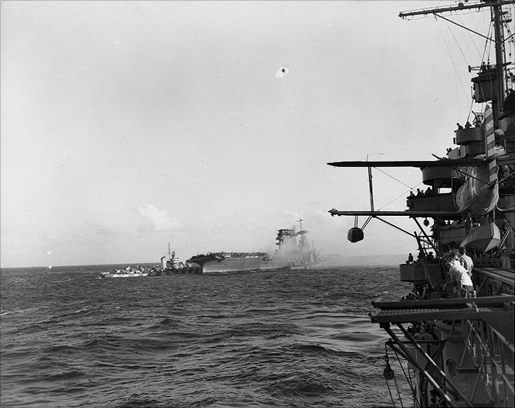 U.S. Navy destroyers alongside the aircraft carrier USS Lexington (CV-2) assist in the ship’s abandonment, after she had been mortally damaged by fires and explosions during the afternoon of 8 May 1942.