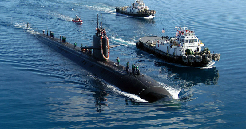 USS San Francisco escorted by two harbor tugs 