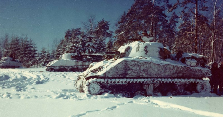 Lined up in a snow-covered field, near St. Vith, Belgium are the M-4 Sherman tanks.