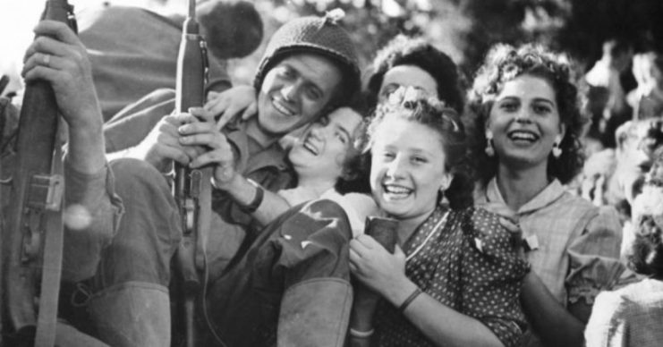 A G.I. getting some love from the recently liberated French ladies, August 26, 1944