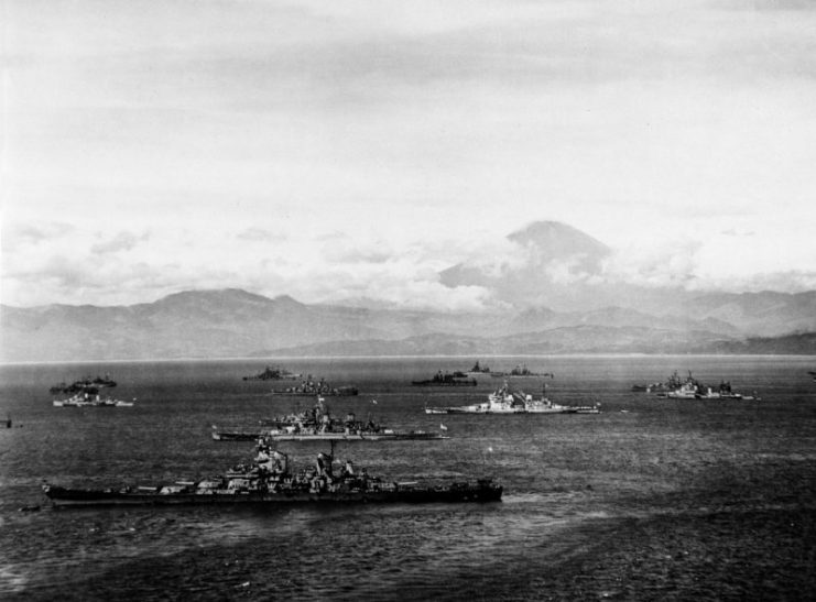 Warships of the U.S. Third Fleet and the British Pacific Fleet in Sagami Wan, 28 August 1945, preparing for the formal Japanese surrender a few days later. Mount Fuji is in the background. Nearest ship is USS Missouri (BB-63), flying Admiral William F. Halsey’s four-star flag. The British battleship HMS Duke of York is just beyond her, with HMS King George V further in. USS Colorado (BB-45) is in the far center distance. Also present are U.S. and British cruisers and U.S. destroyers.