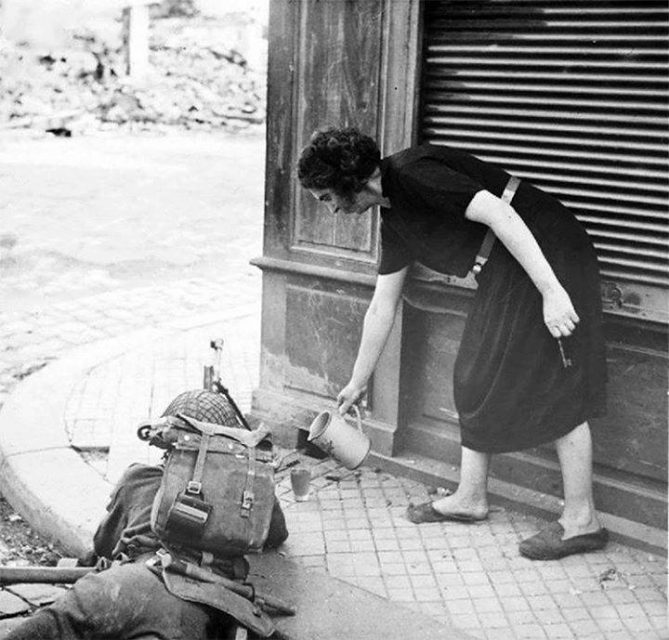 French women pours a hot cup of tea for a British soldier fighting in Normandy, 1944