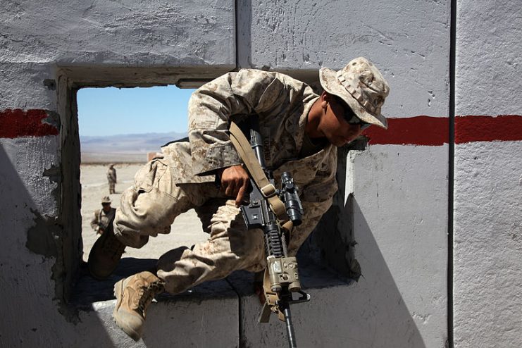 U.S. Marine Corps Lance Cpl. Luke Lozano, a rifleman with 2nd Platoon, India Company, 3rd Battalion, 7th Marine Regiment, jumps through a window while conducting rehearsals for a company assault during an Integrated Training Exercise