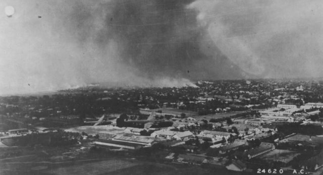 A pair of American B-24 “Liberator” in flight over Ploiesti on a background of fire