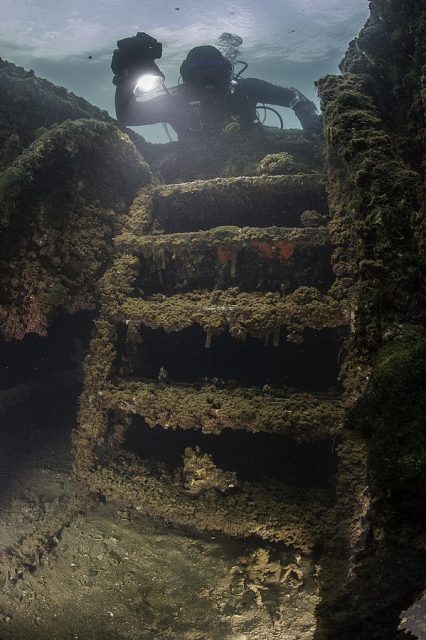 An NPS diver examines & documents the wreckage of the USS Arizona in 2015.