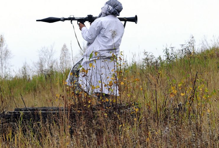 A mock insurgent prepares to fire a rocket-propelled grenade at a convoy as soldiers from the 95th Chemical Company, 6th Engineer Battalion, conduct battle drills at the Infantry Squad Battle Course