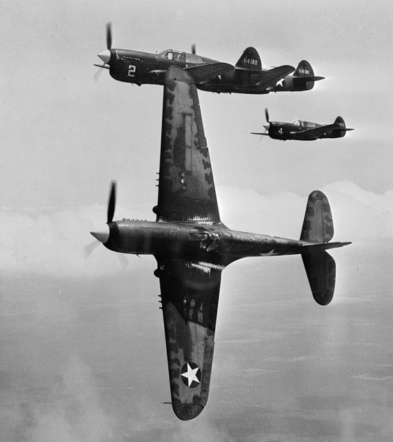 In the vicinity of Moore Field, Texas. The lead ship in a formation of P-40s is peeling off for the “attack” in a practice flight at the US Army Air Forces advanced flying school.