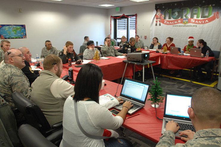 Volunteers monitor phones and computers while tracking Santa Claus at the NORAD Tracks Santa Operations Center on Peterson Air Force Base, Colo., Dec. 24.