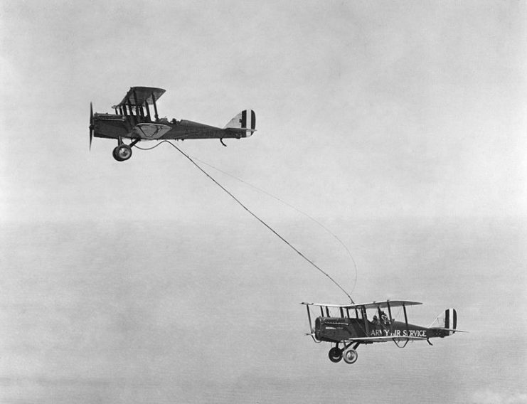 Capt. Lowell H. Smith and Lt. John P. Richter performing the first aerial refueling on 27 June 1923. The DH-4B biplane remained aloft over the skies of Rockwell Field in San Diego, California, for 37 hours. The airfield’s logo is visible on the aircraft.