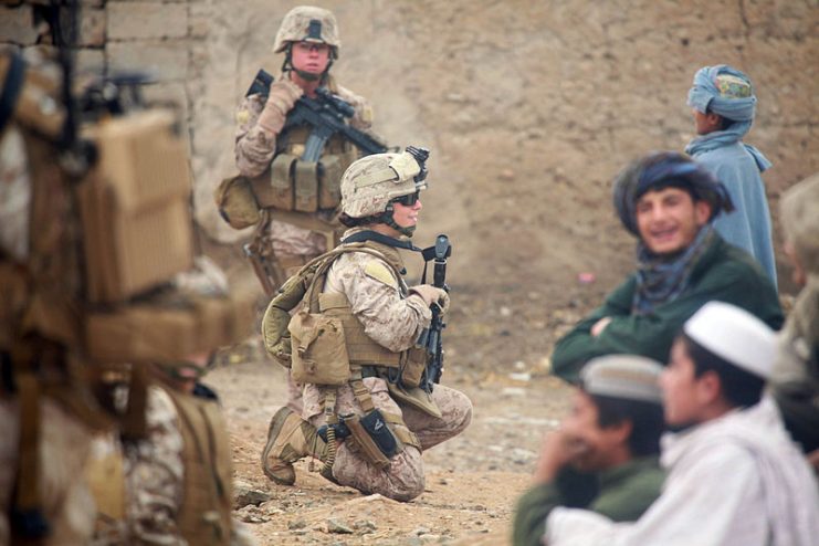 U.S. Marine Corps Lance Cpl. Sienna De Santis and U.S. Navy Petty Officer 3rd Class Heidi Dean, both with Female Engagement Team, India Company, 3rd Battalion, 5th Marine Regiment, Regimental Combat Team 2, greet children during a patrol in Sangin Valley, Afghanistan