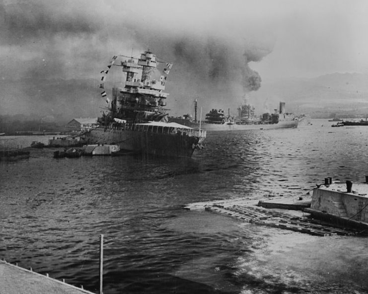 The U.S.S. Neosho, navy oil tanker, cautiously backs away from her berth (right center) in a successful effort to escape the Japanese attack on Pearl Harbor, Dec. 7, 1941.