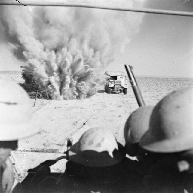 A mine explodes close to a British artillery tractor as it advances through enemy minefields and wire to the new front line