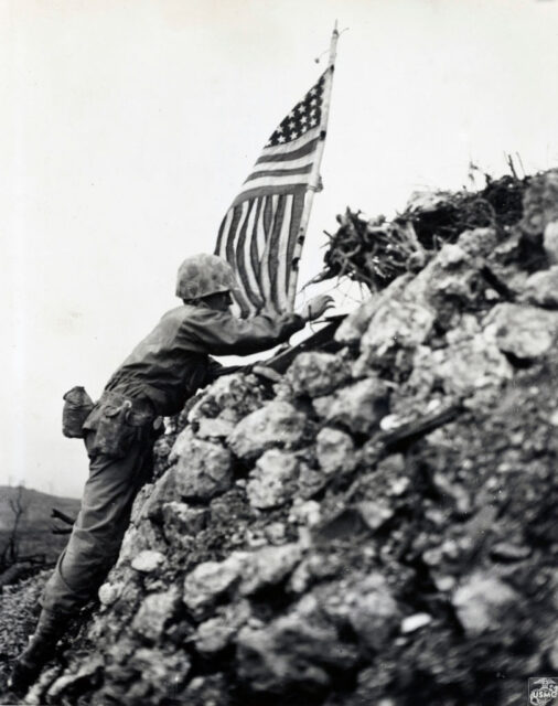 Lt. Col. R.P. Ross, Jr. placing the American flag on the remnants of Shuri Castle