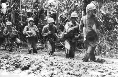 Marines trudge forward through calf–deep mud on the Numa Numa Trail, Bougainville—November 1943