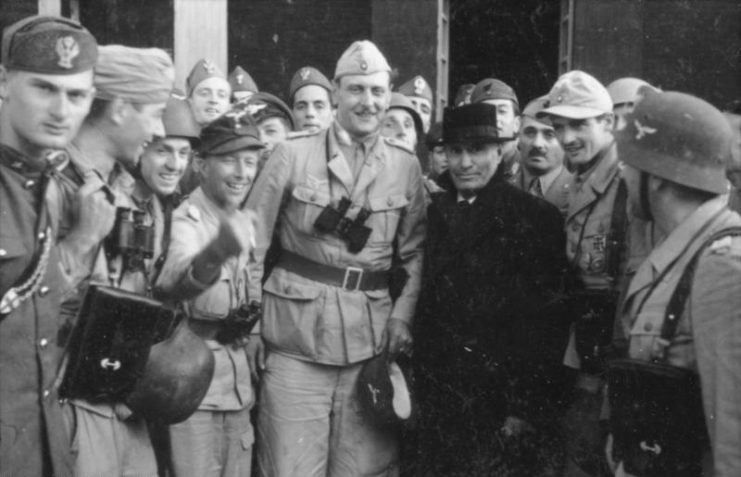 Otto Skorzeny (centre, binoculars hanging from neck) with the liberated Mussolini – 12 September 1943. By Bundesarchiv Bild CC-BY-SA 3.0