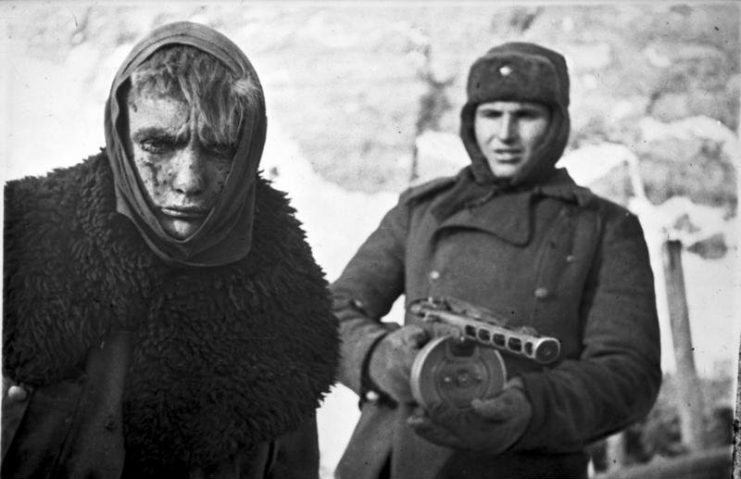 A Red Army soldier marches a German soldier into captivity. By Bundesarchiv Bild CC-BY-SA 3.0