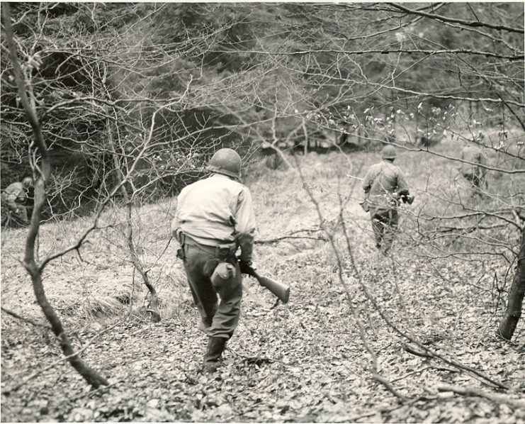 A patrol of Company F, 3rd Battalion, 18th Infantry Regiment, 1st Infantry Division, searches the woods between Eupen and Butgenbach, Belgium, for German parachutists who were dropped in that area.