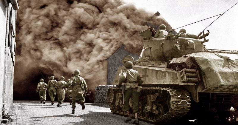 Soldiers of the 55th Armored Infantry Battalion and tank of the 22nd Tank Battalion, 11 Armored Division, move through smoke filled street. Wernberg, Germany.