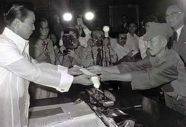 Japanese imperial army soldier Hiroo Onoda (R) offering his military sword to Philippine President Ferdinand E. Marcos (L) on the day of his surrender, March 11, 1974.