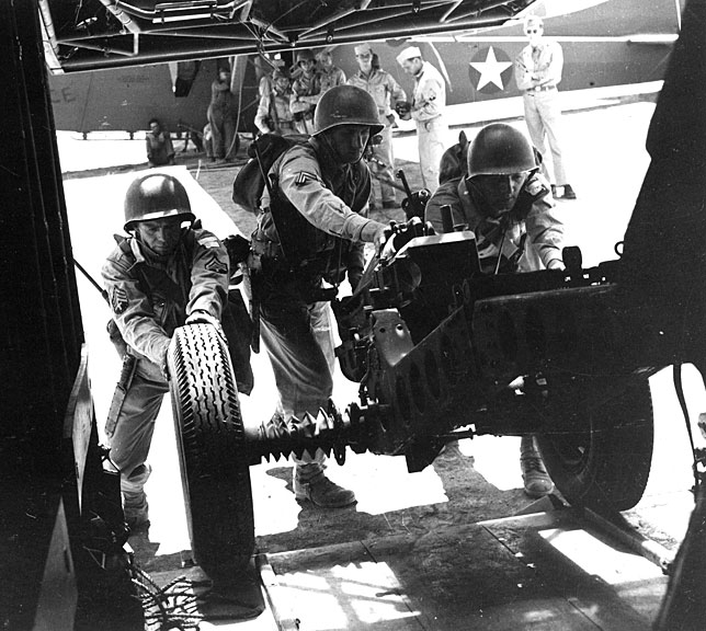 Members of the 504th Parachute Infantry Regiment prepare a weapon for stowage aboard a glider.April 1943