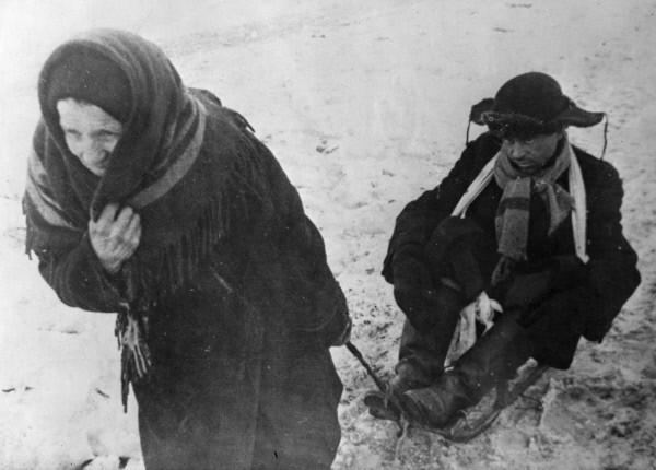 An old woman sledging a starving young man in besieged Leningrad. By RIA Novosti archive CC BY-SA 3.0
