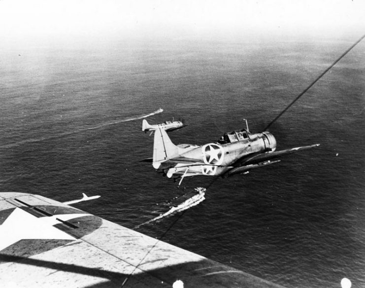 SBD in flight over an escort carrier during Operation Torch