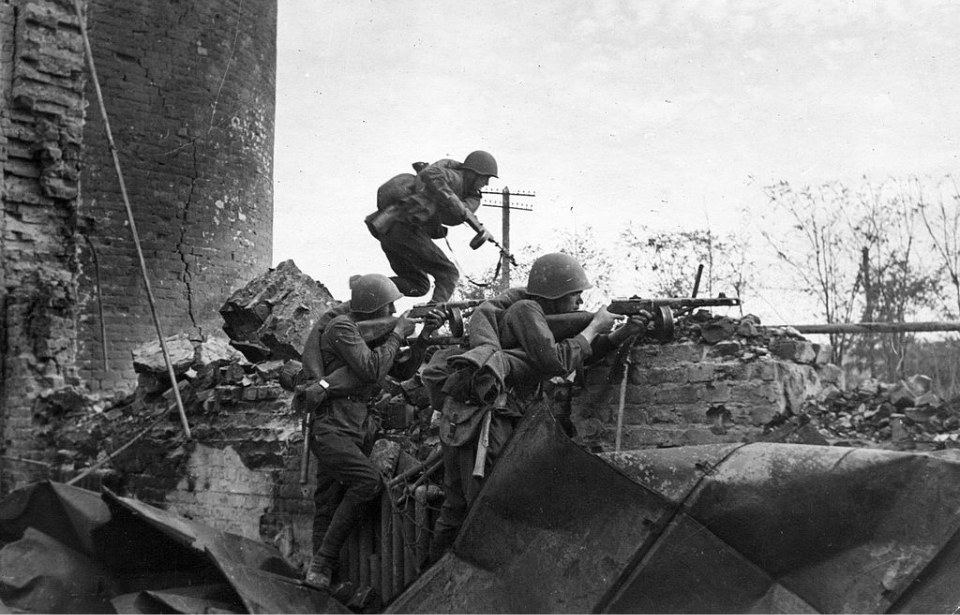 Red Army troops firing their guns from the remnants of a building