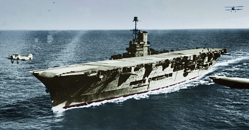 The British Royal Navy aircraft carrier HMS Ark Royal (91) photographed circa 1939. A Fairey Swordfish aircraft is taking off as another approaches from astern. Two are visible in the background.