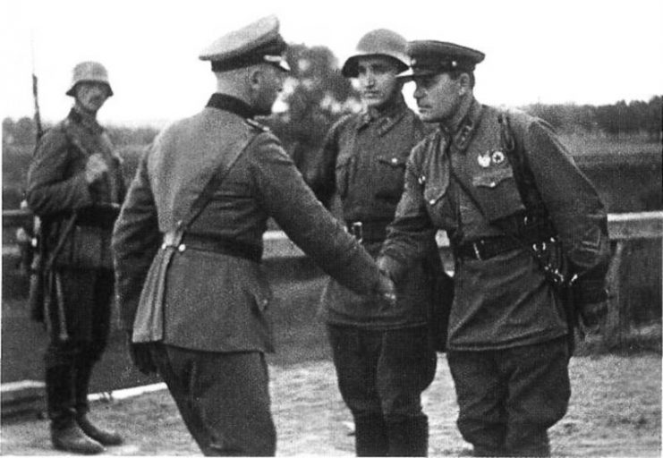 A German and a Soviet officer shaking hands at the end of the Invasion of Poland.