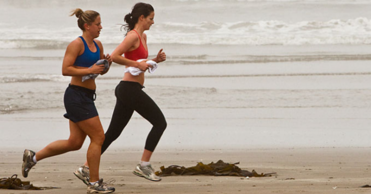 Two female joggers on Morro Strand State Beach, Morro Bay, CA. By Mike Baird CC BY 2.0